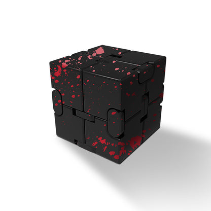 user engaging with patterned metal stress cube