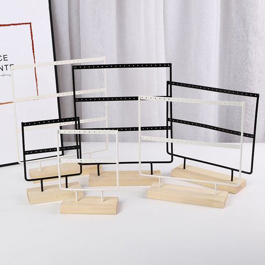 sleek white metal earring holder with wooden base