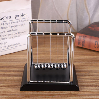 Close-up of black base Newton's Cradle in action