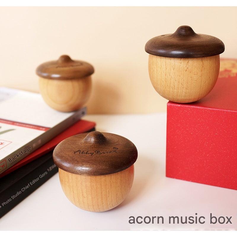 wooden music box acorn design on bookshelf