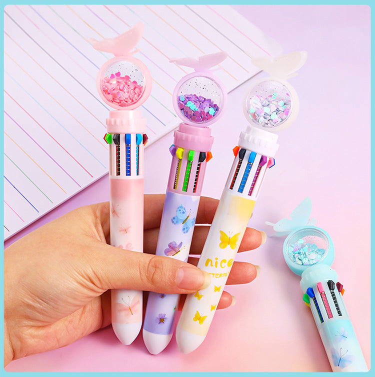 Hand holding a colorful ballpoint pen over notebook image