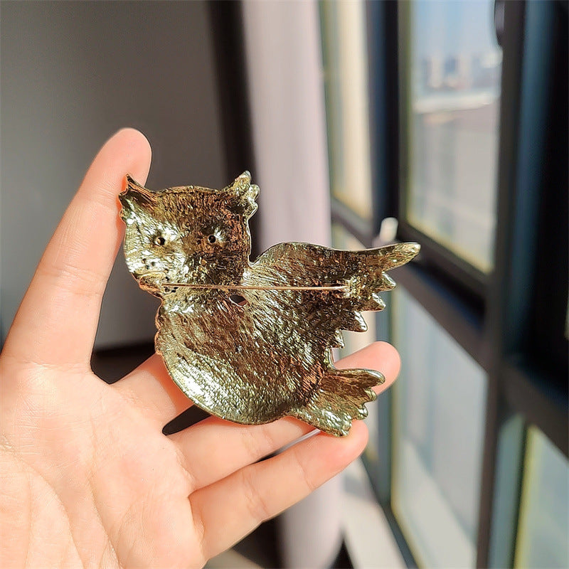 Close-up of rhinestone owl brooch detailing