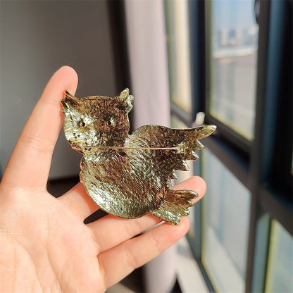 Close-up of rhinestone owl brooch detailing