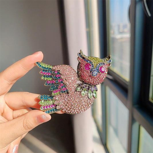 Close-up of rhinestone owl brooch detailing